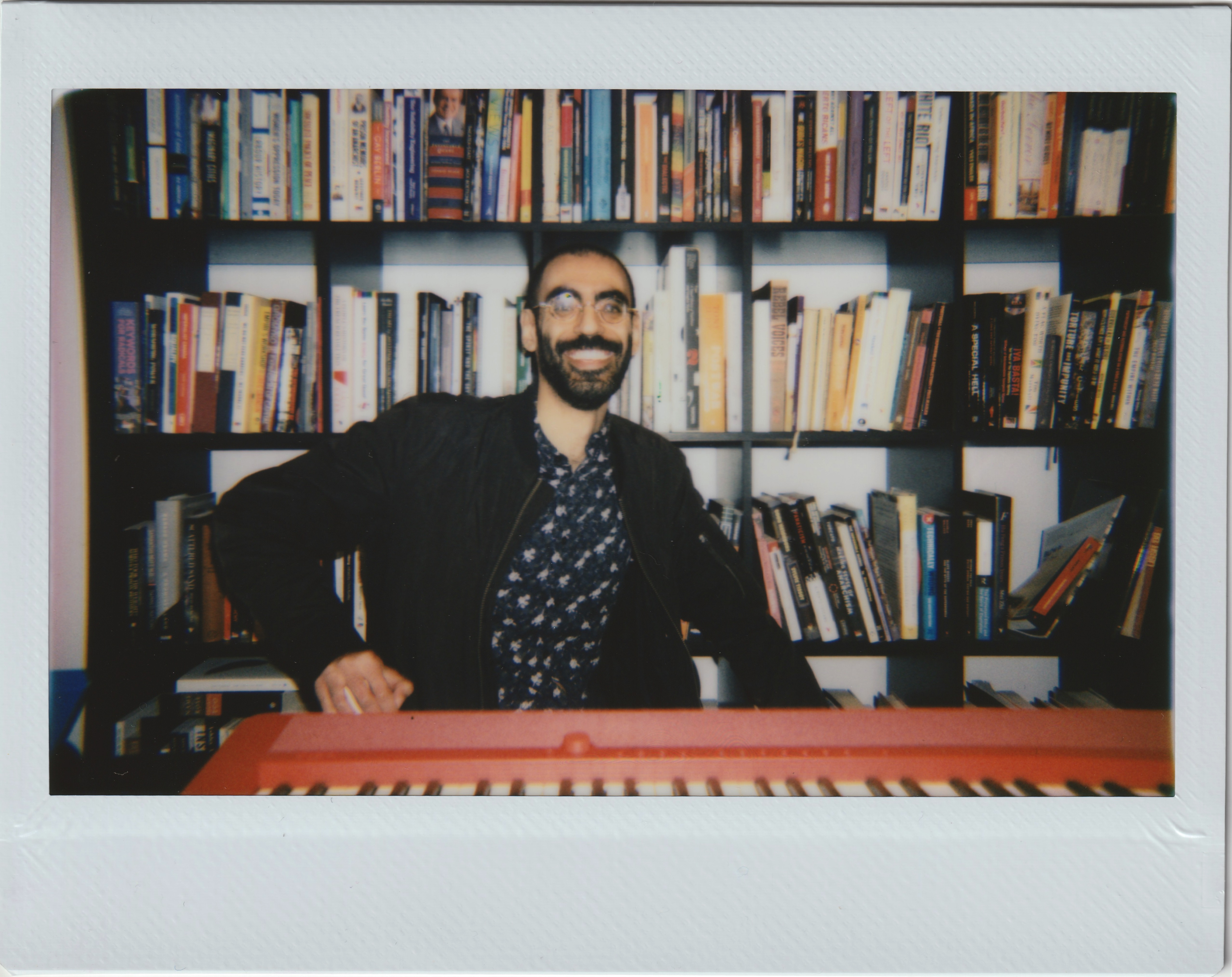 a polaroid of me (beanboy) sitting in front of bcj's bookcase